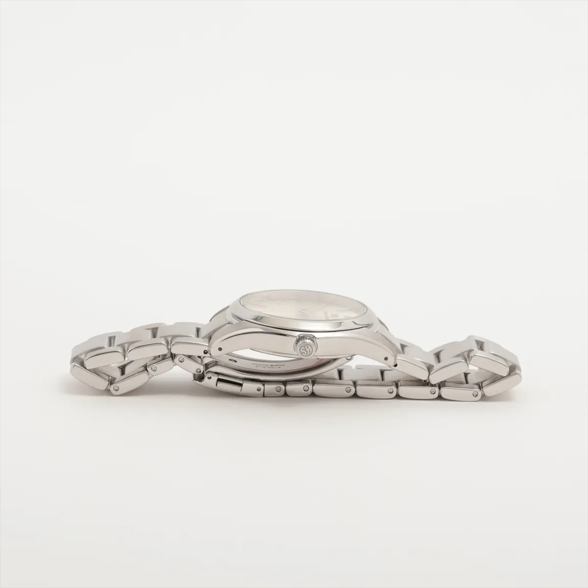 Stainless steel wristwatch with a silver dial, baton indices and a three-link bracelet.