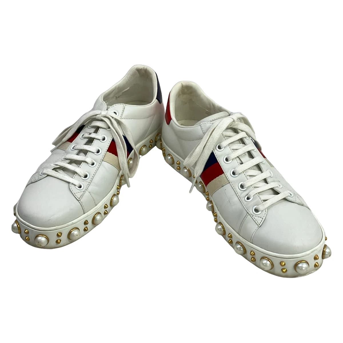 Low-top sneakers in white with burgundy and navy side stripes.