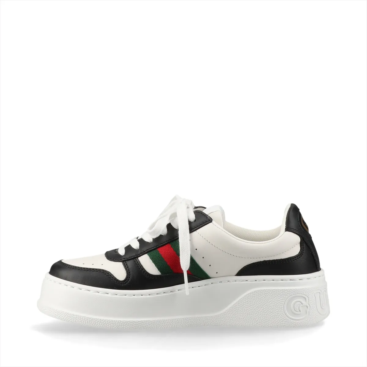 Pair of thick-soled low-top sneakers in black and white with a red and green striped band.