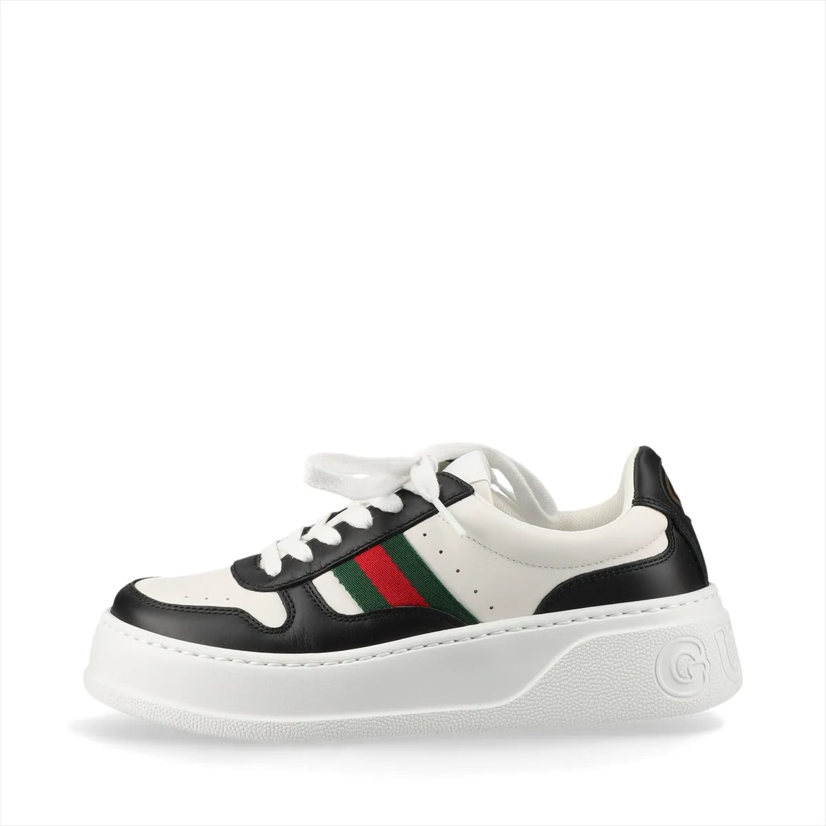 Pair of thick-soled low-top sneakers in black and white with a red and green striped band.