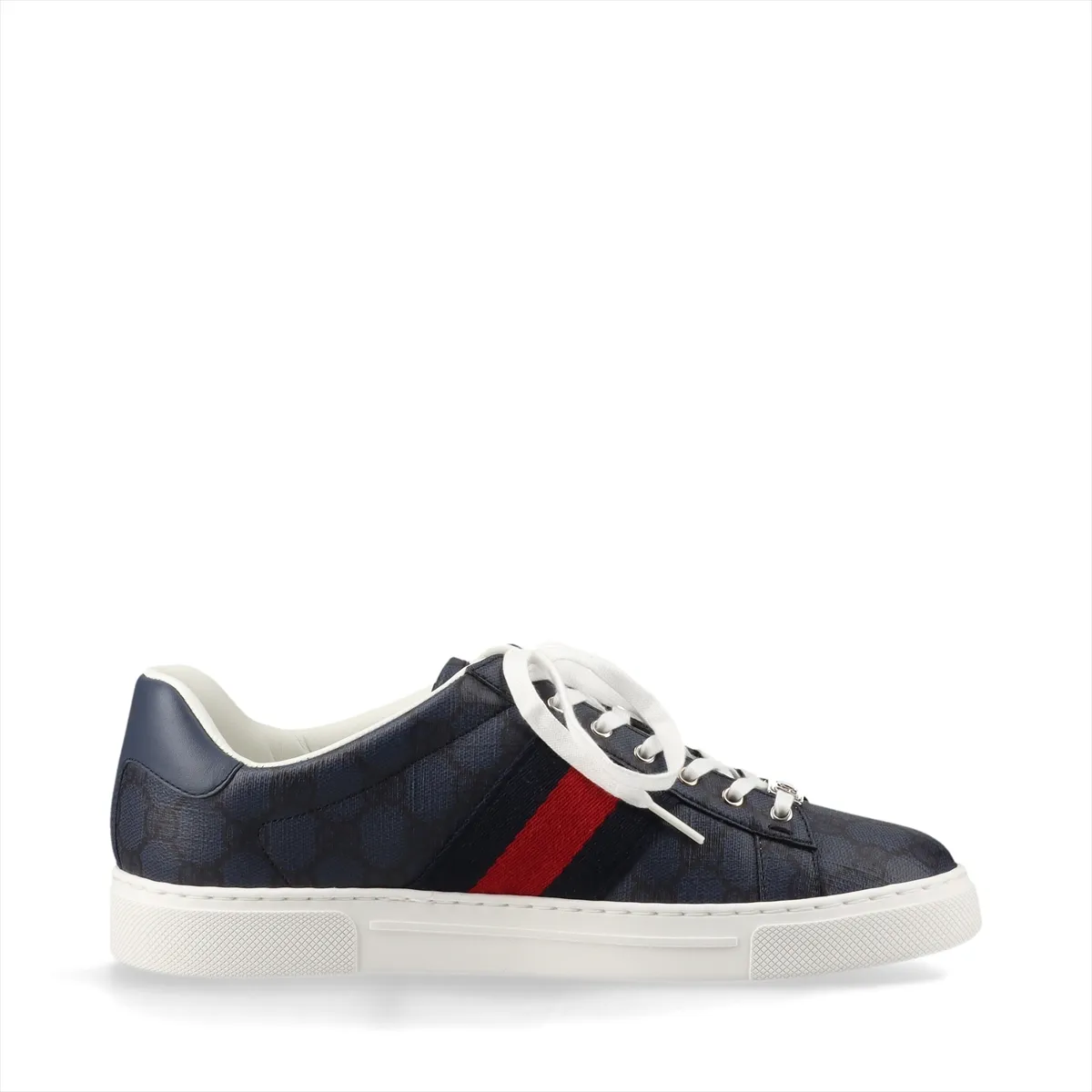 Pair of low-top sneakers in patterned fabric with leather trim and a red-and-green stripe.