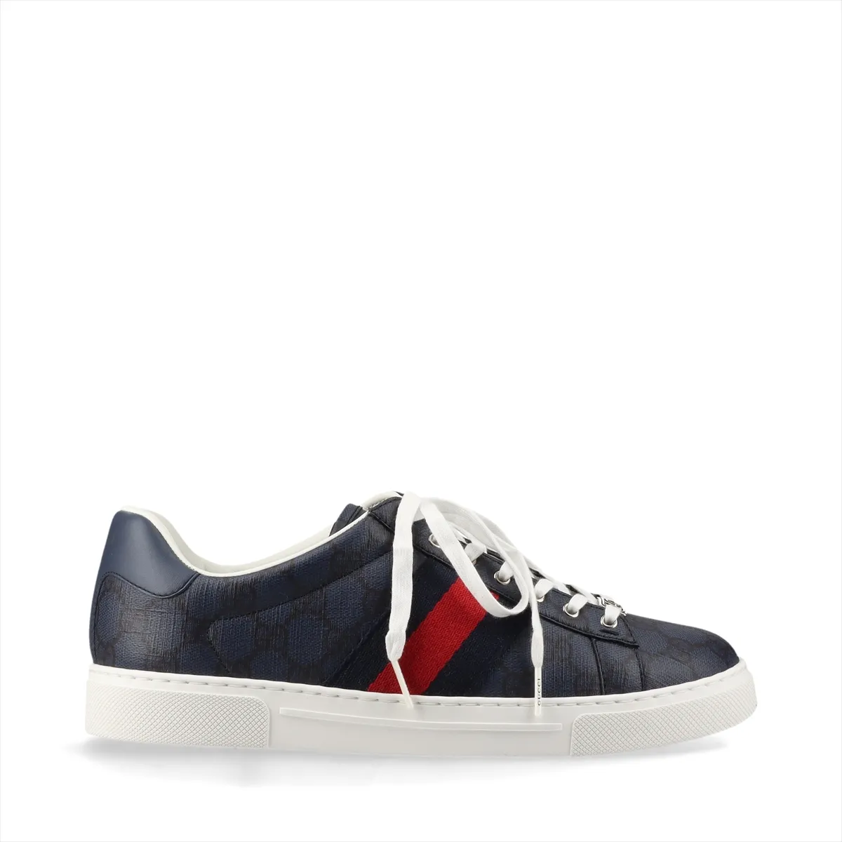 Pair of low-top sneakers in patterned fabric with leather trim and a red-and-green stripe.