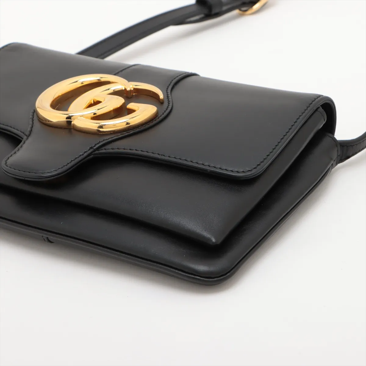 Product photograph of a small black leather bag with a shoulder strap.