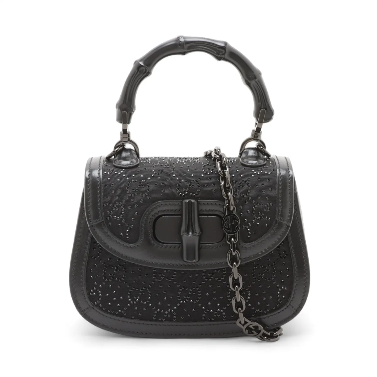 Small structured black handbag with a curved bamboo top handle and a jewelled clasp.