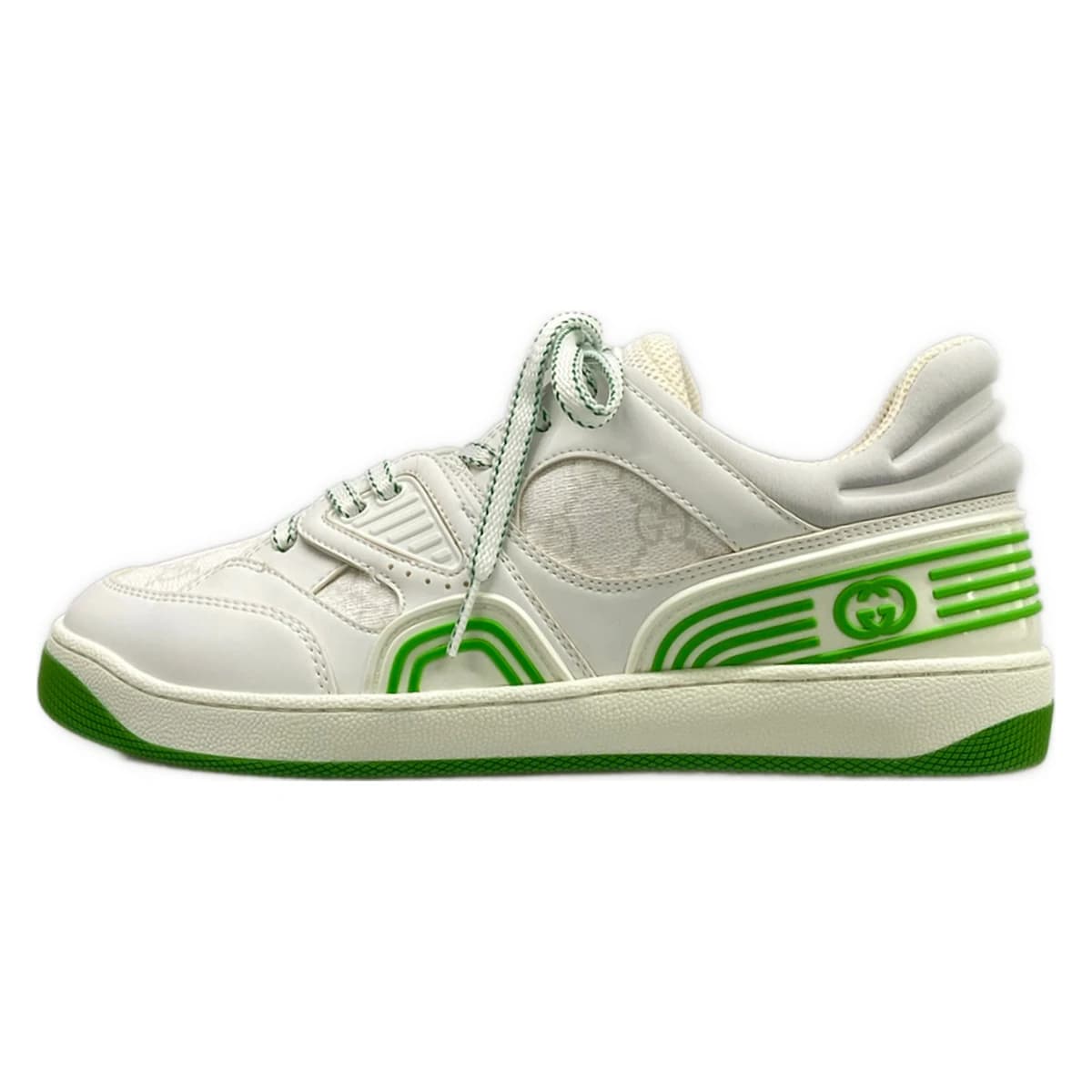 Pair of white low-top shoes with light green trim and a monogram-patterned panel.