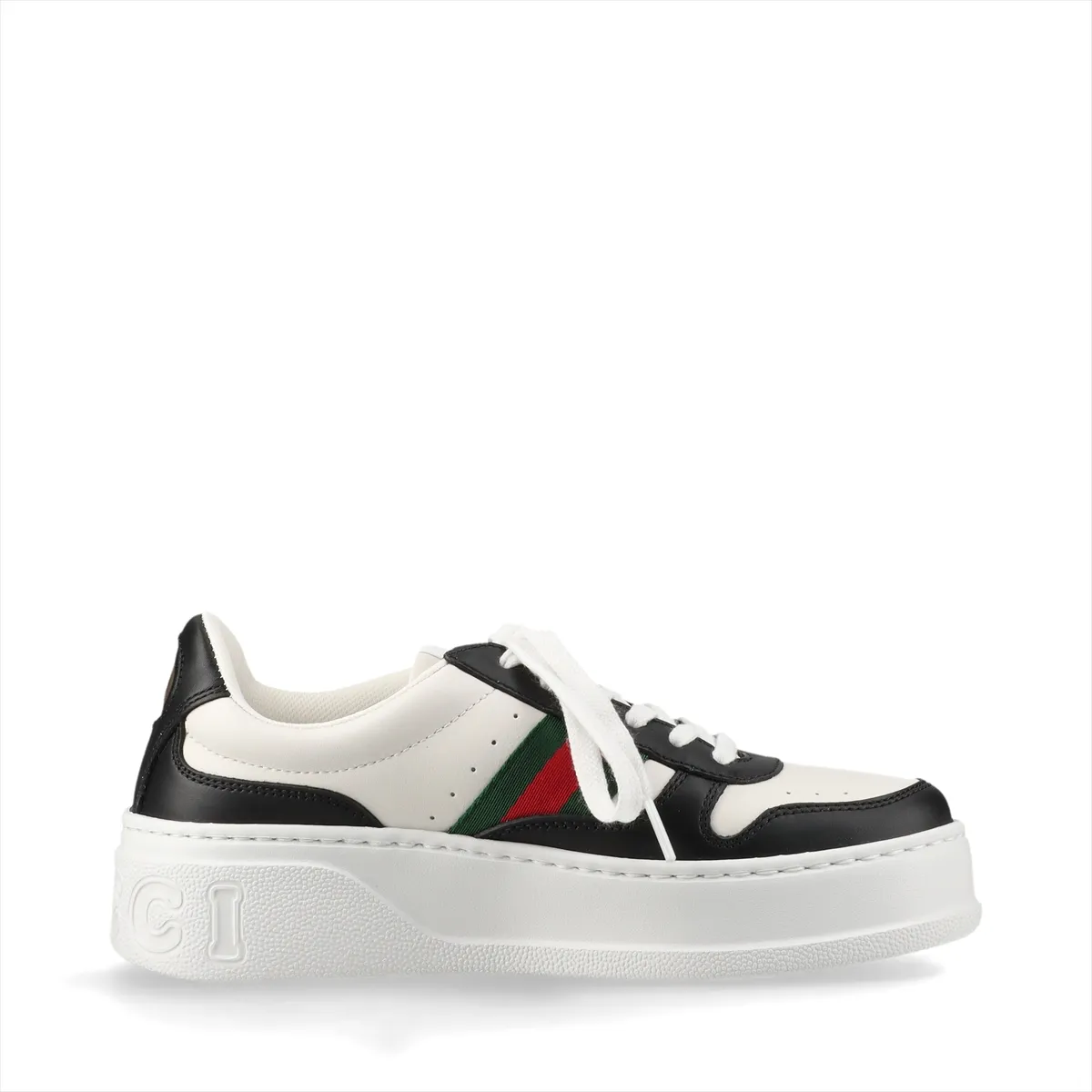 Platform low-top sneakers in black and white with a striped side band and metal logo detail.