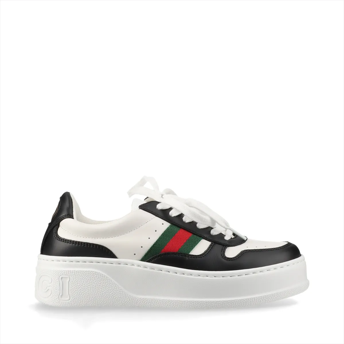 Platform low-top sneakers in black and white with a striped side band and metal logo detail.