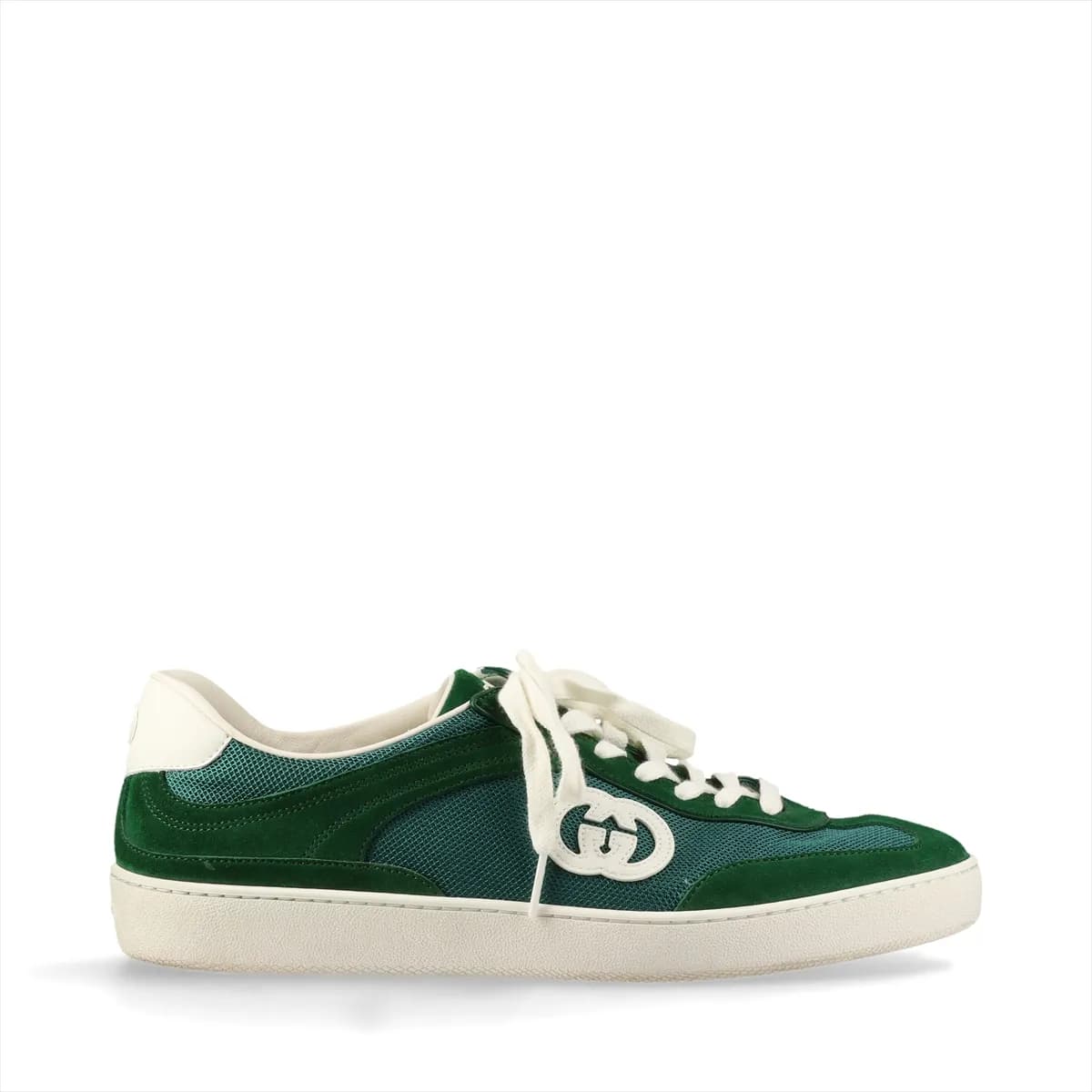 Green mesh and leather sneaker with a metal logo detail, shown in profile.