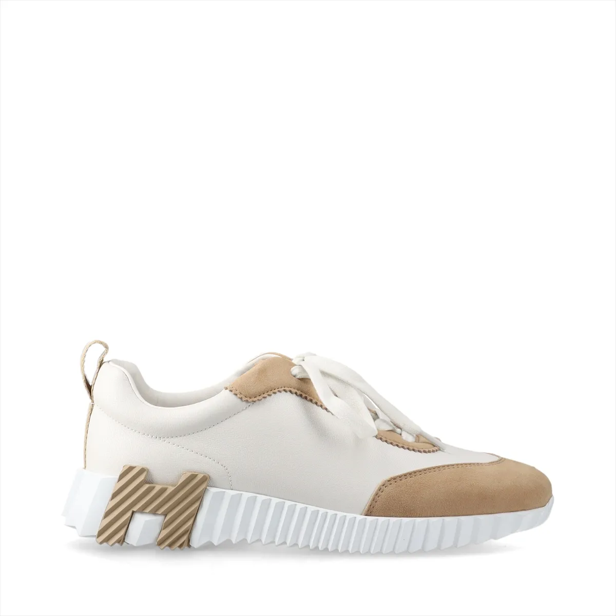 White and beige low-top sneakers in leather and suede with white laces and a chunky sole.