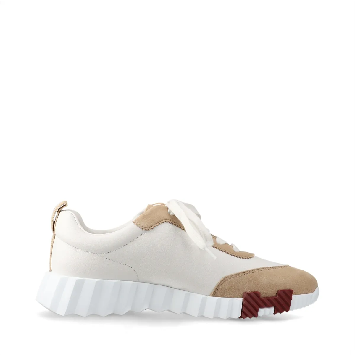 White and beige low-top sneakers in leather and suede with white laces and a chunky sole.
