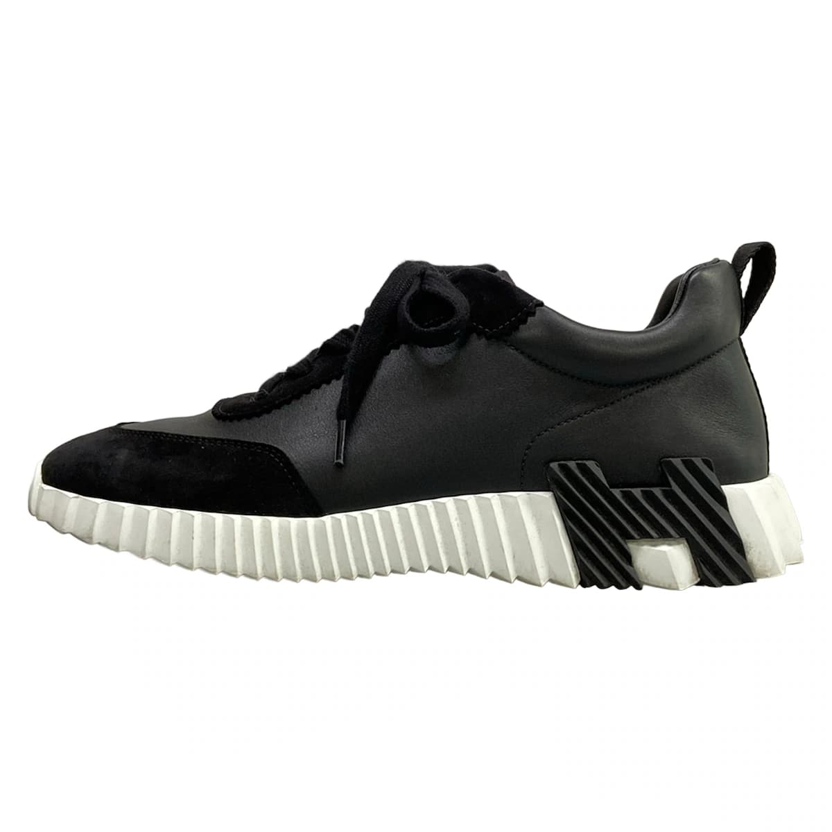 Pair of black low-top sneakers with a thick sole, shown side on.