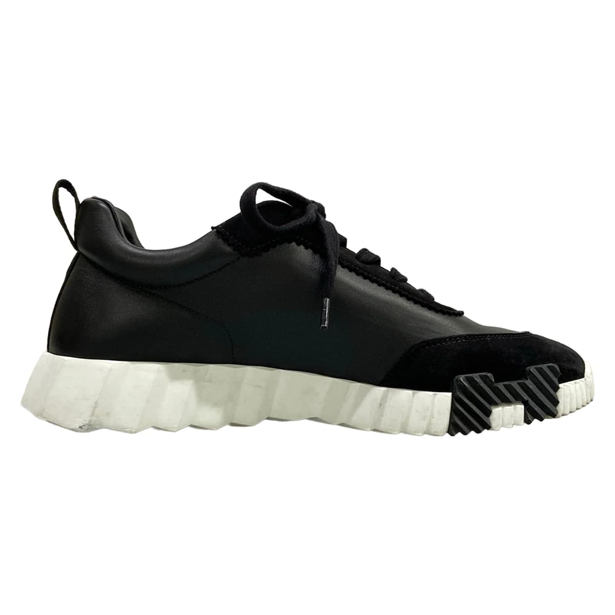 Pair of black low-top sneakers with a thick sole, shown side on.