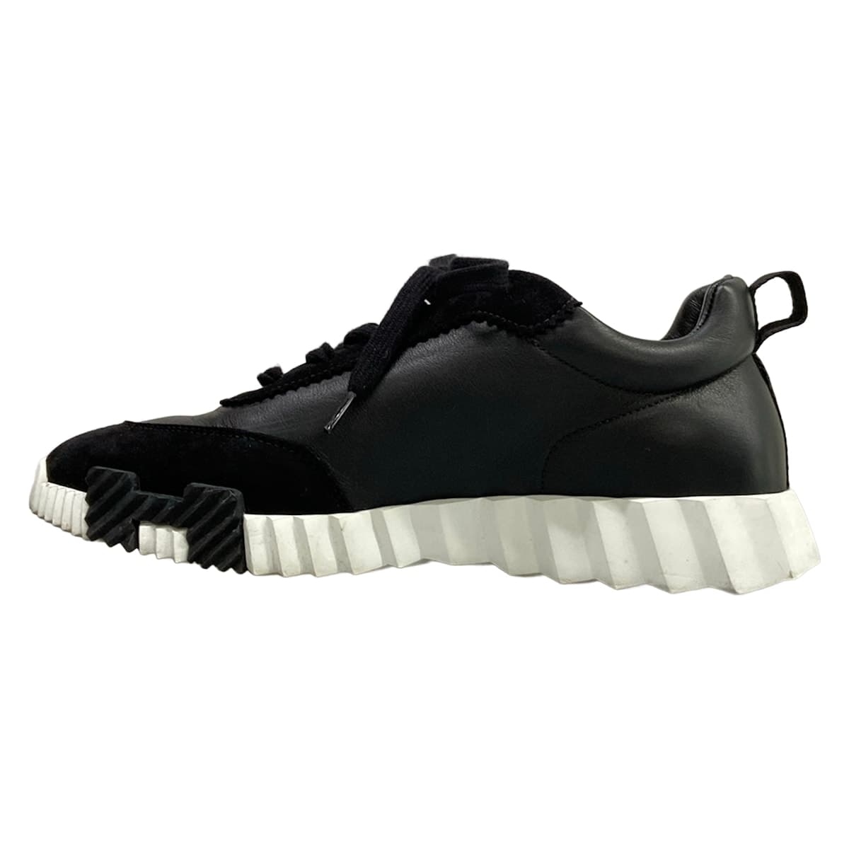 Pair of black low-top sneakers with a thick sole, shown side on.