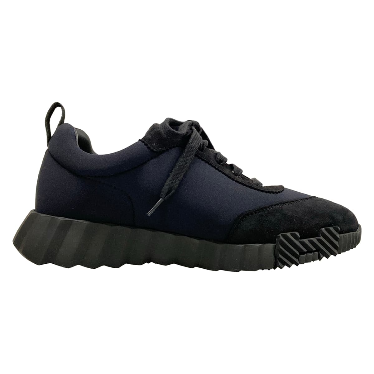 Black low-top trainers with a white sole, shown from the side.