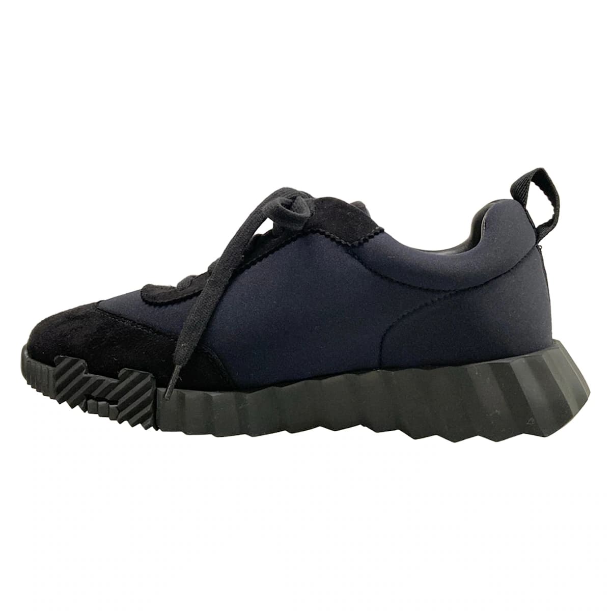 Black low-top trainers with a white sole, shown from the side.