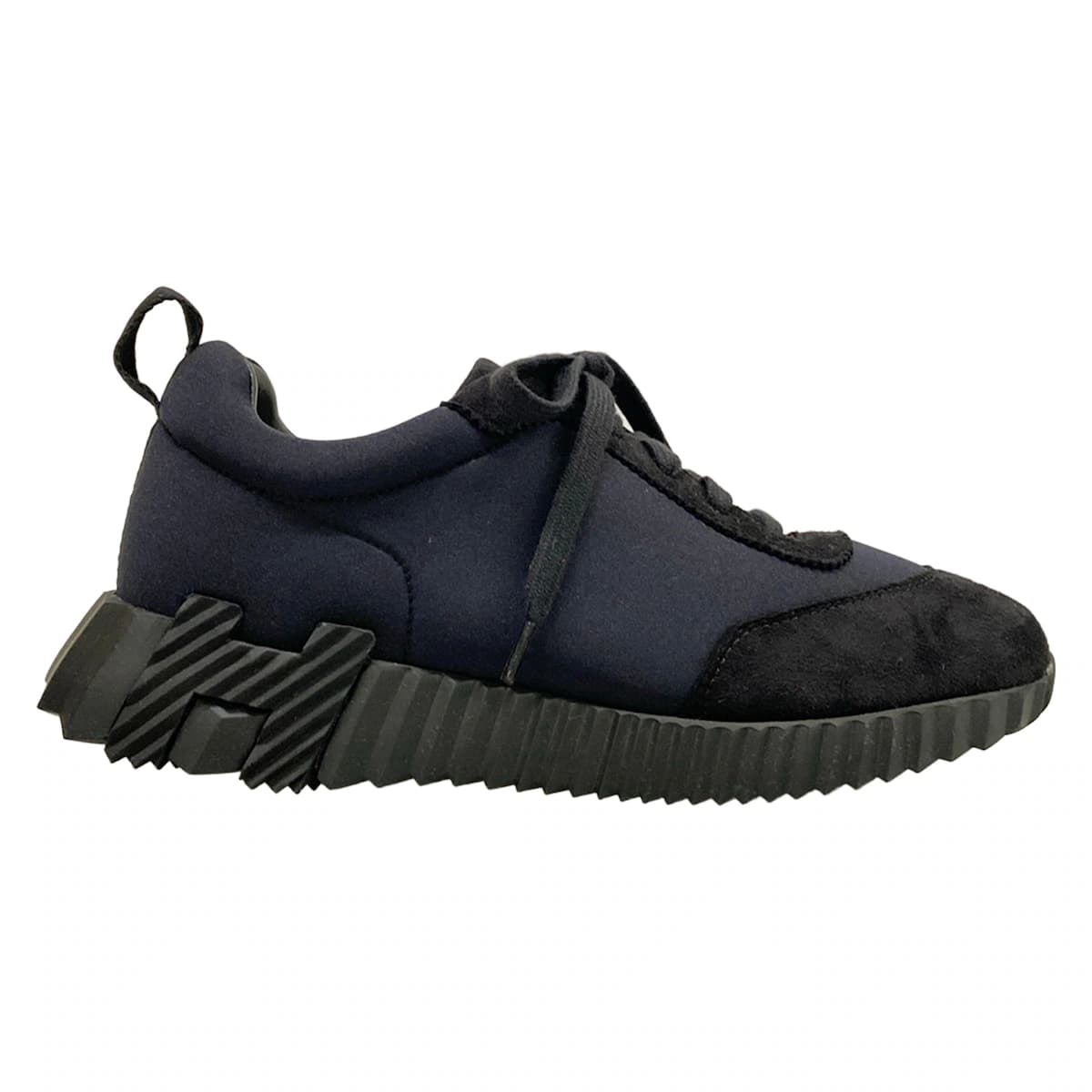 Black low-top trainers with a white sole, shown from the side.