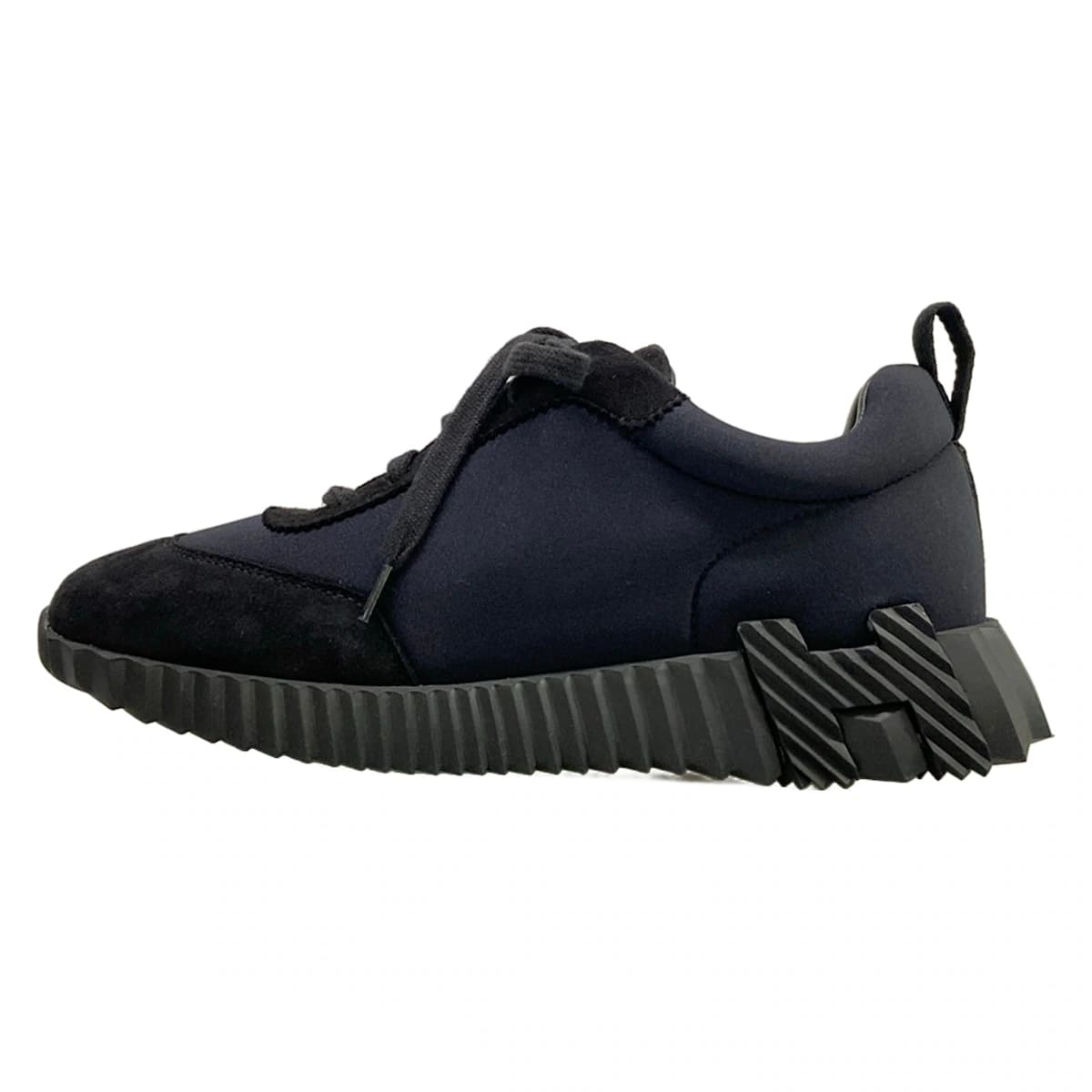 Black low-top trainers with a white sole, shown from the side.