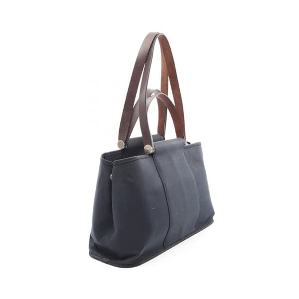 Black canvas tote bag with leather-trimmed handles and a detachable strap.