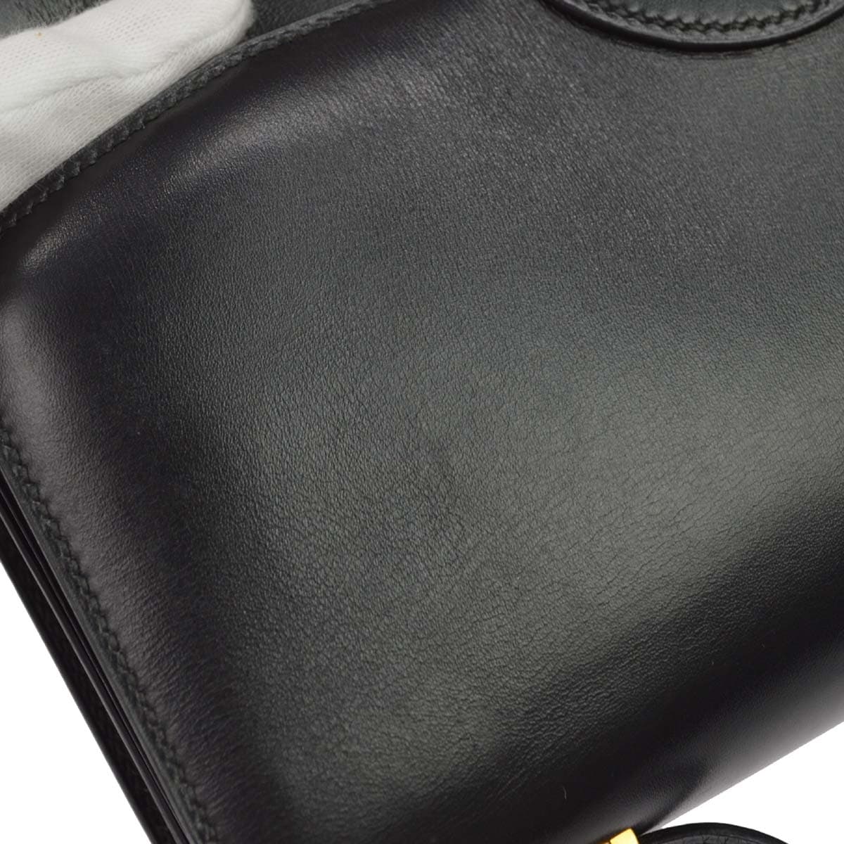Black smooth leather shoulder bag with a flap front and a long strap