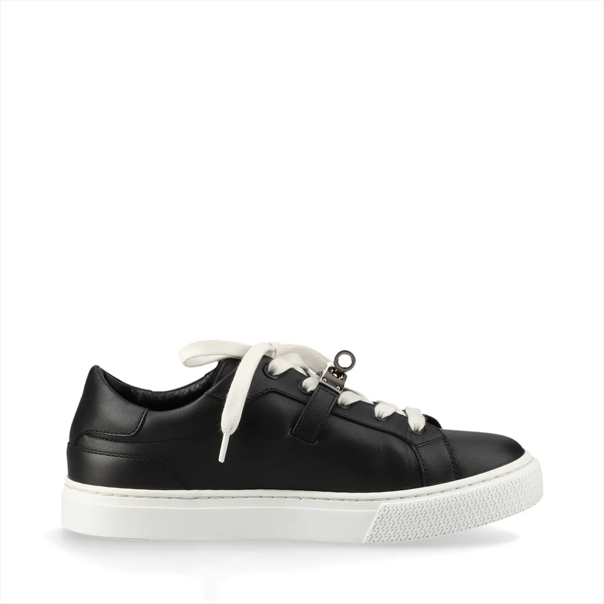 Black and white leather low-top sneaker with a metal turn-lock clasp at the side.