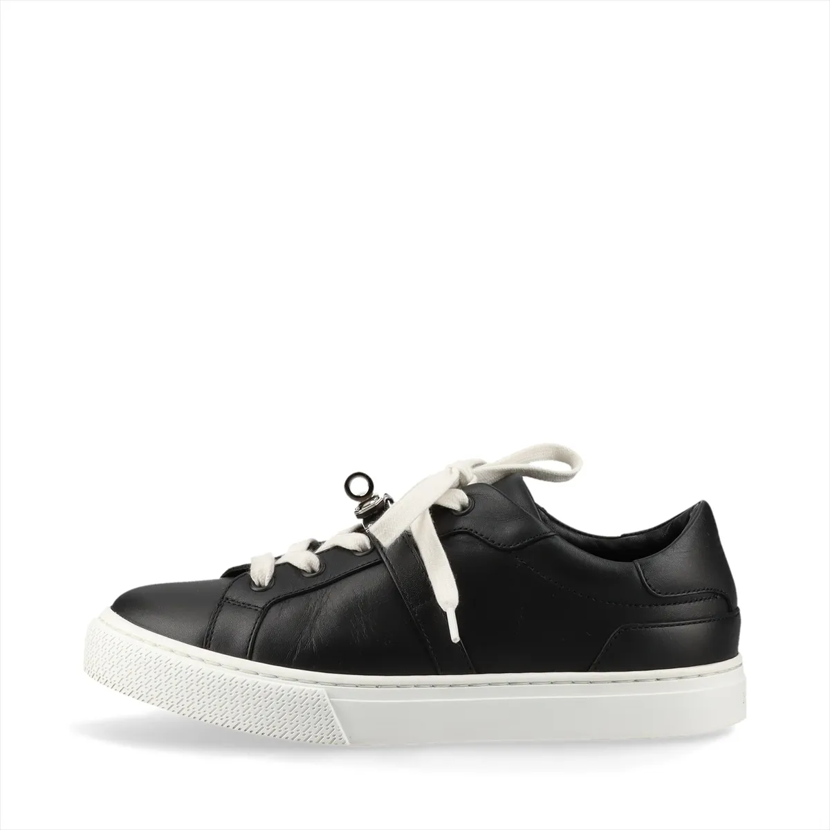 Black and white leather low-top sneaker with a metal turn-lock clasp at the side.