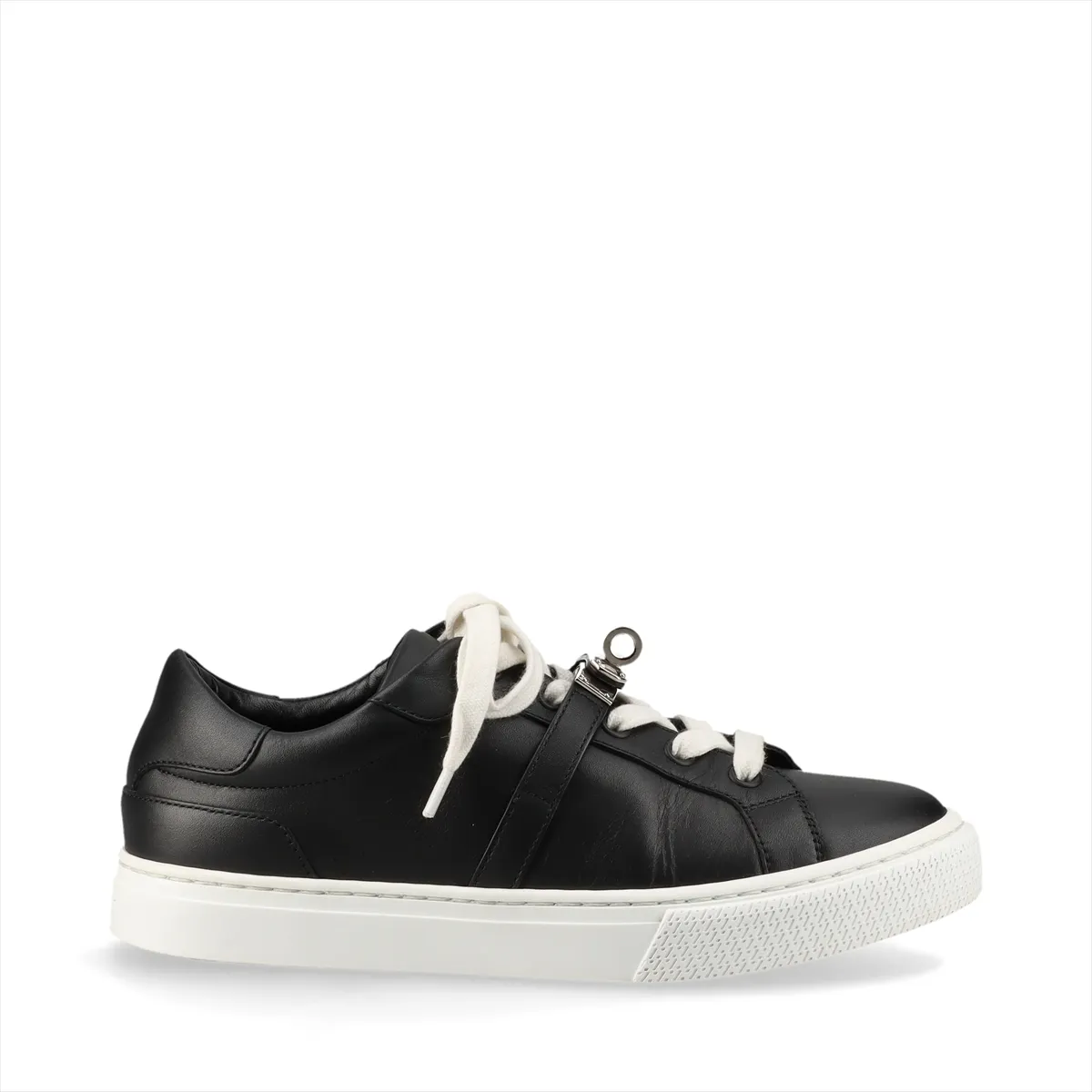 Black and white leather low-top sneaker with a metal turn-lock clasp at the side.