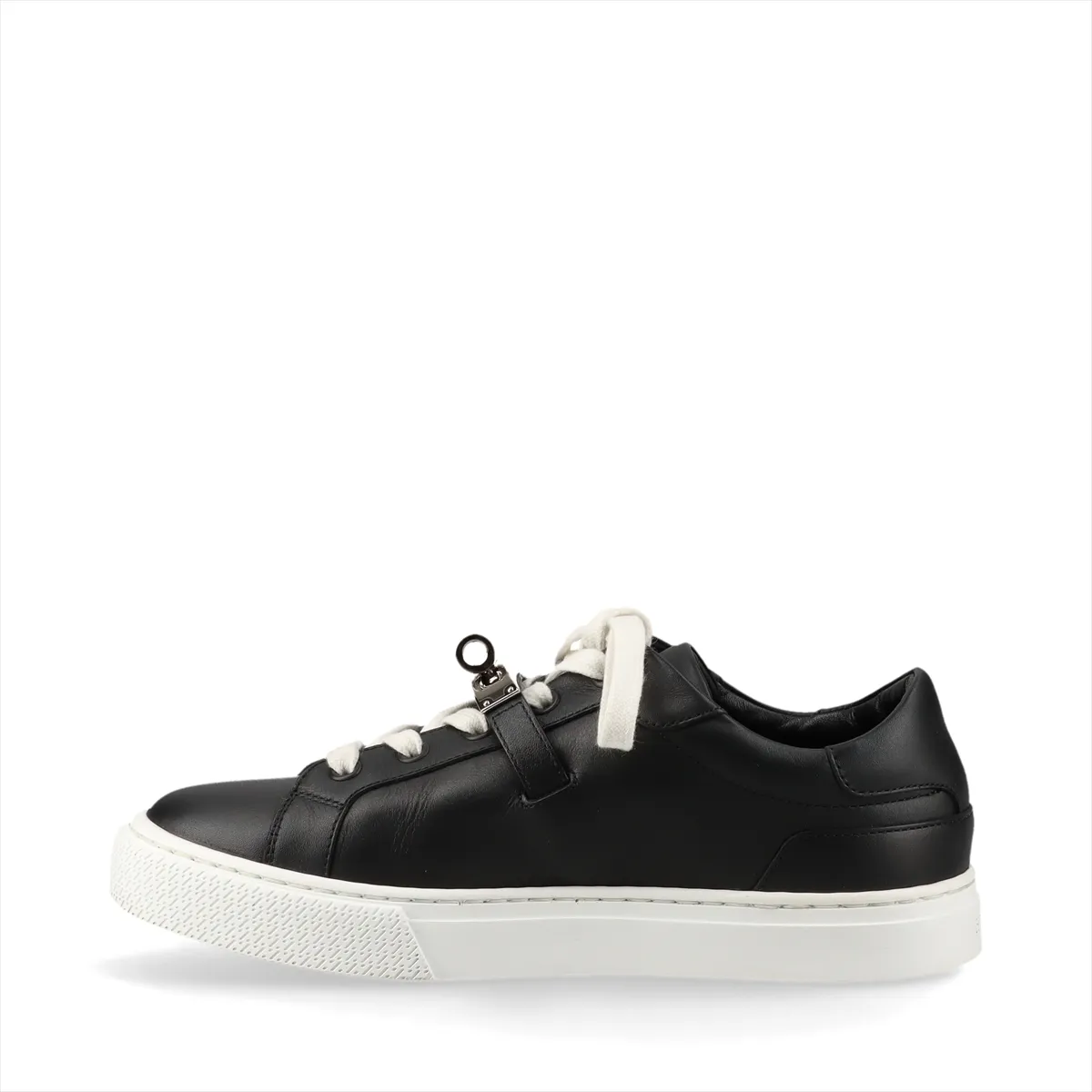 Black and white leather low-top sneaker with a metal turn-lock clasp at the side.