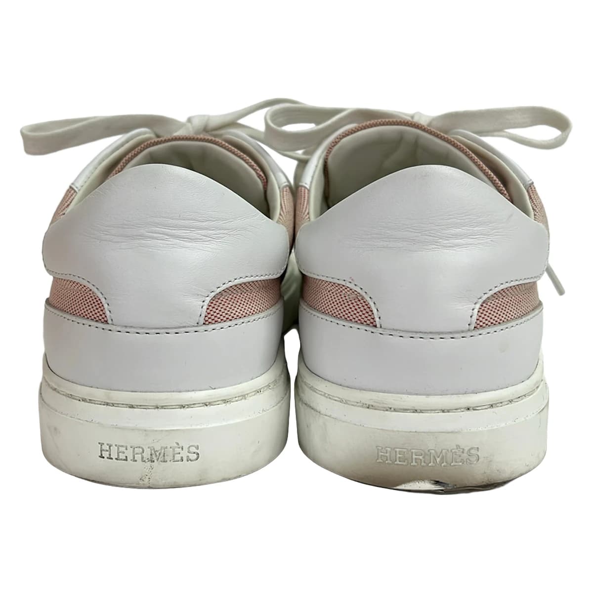 White leather low-top sneakers with red trim detailing.