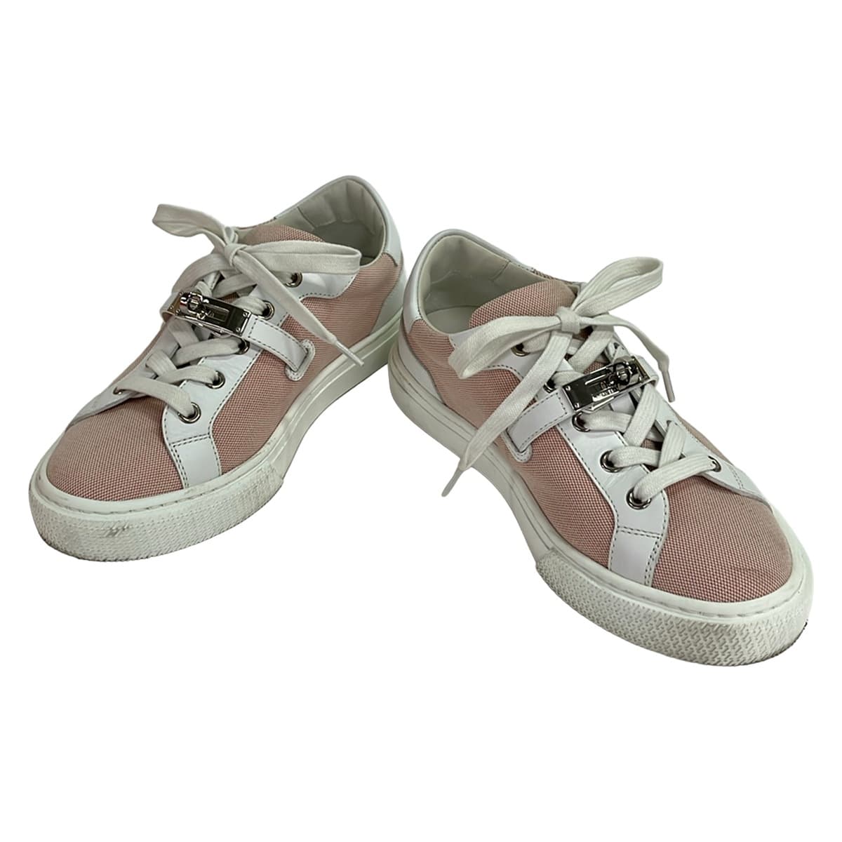 White leather low-top sneakers with red trim detailing.