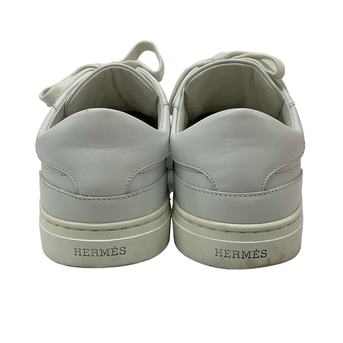 Pair of white low-top lace-up shoes shown from the side on a plain background.