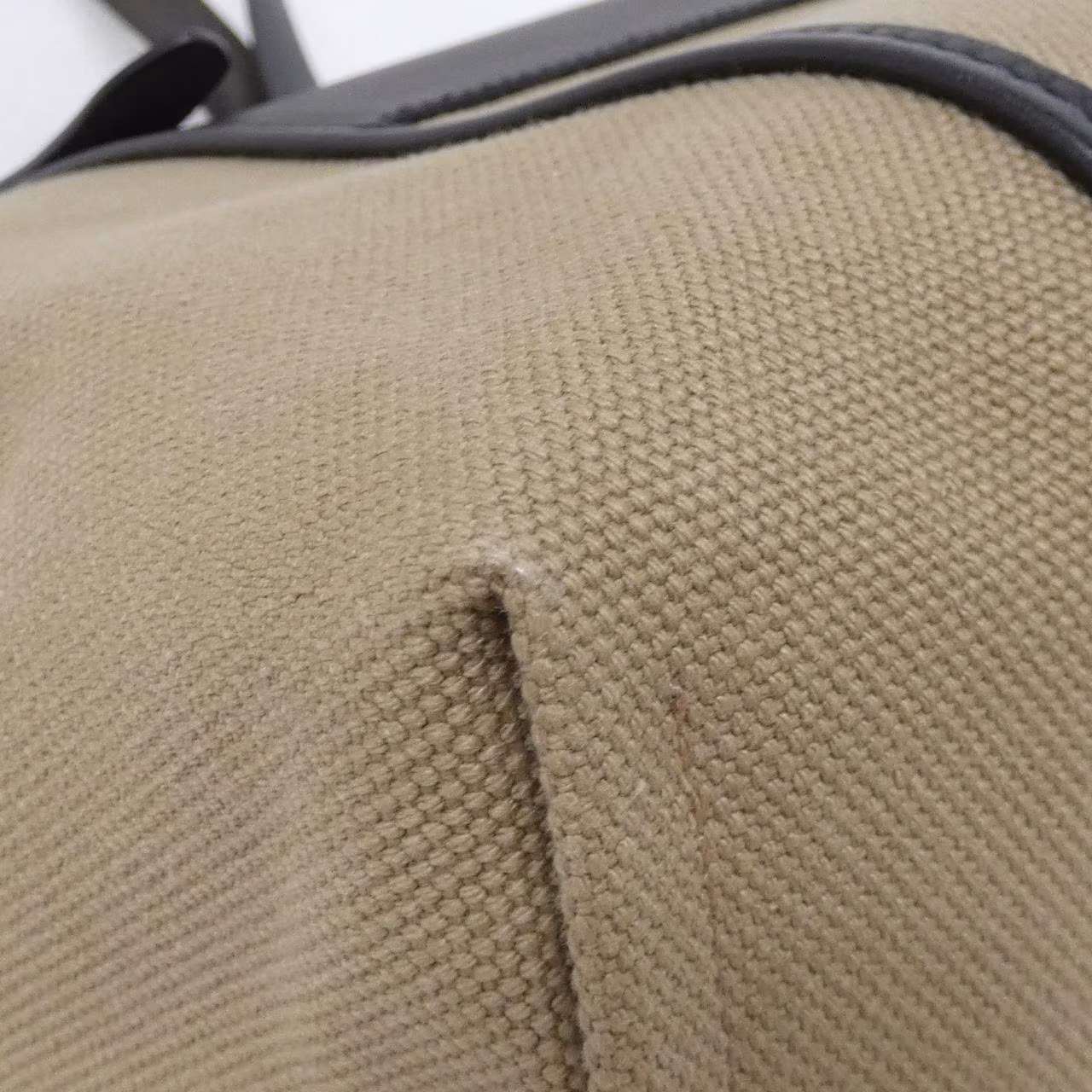 Structured brown bag with a front flap pocket and a flat top handle.