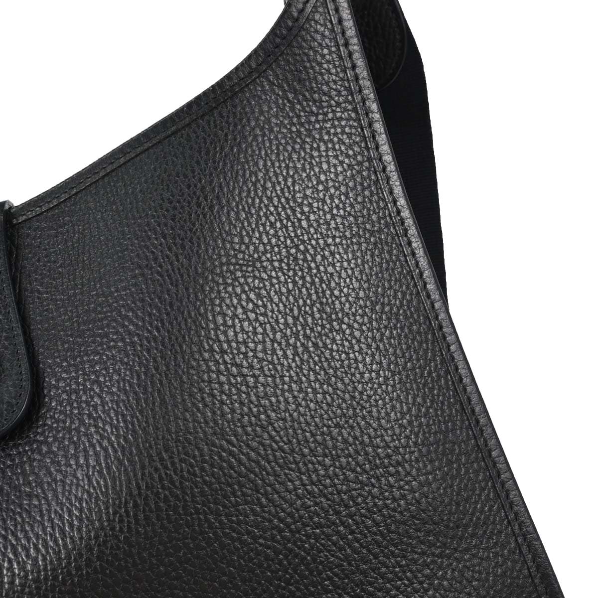 Black grained leather shoulder bag with a perforated H on the front and a long strap.