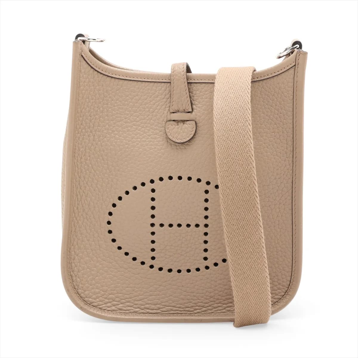 Small beige leather shoulder bag with perforated H on the front and a long woven strap.