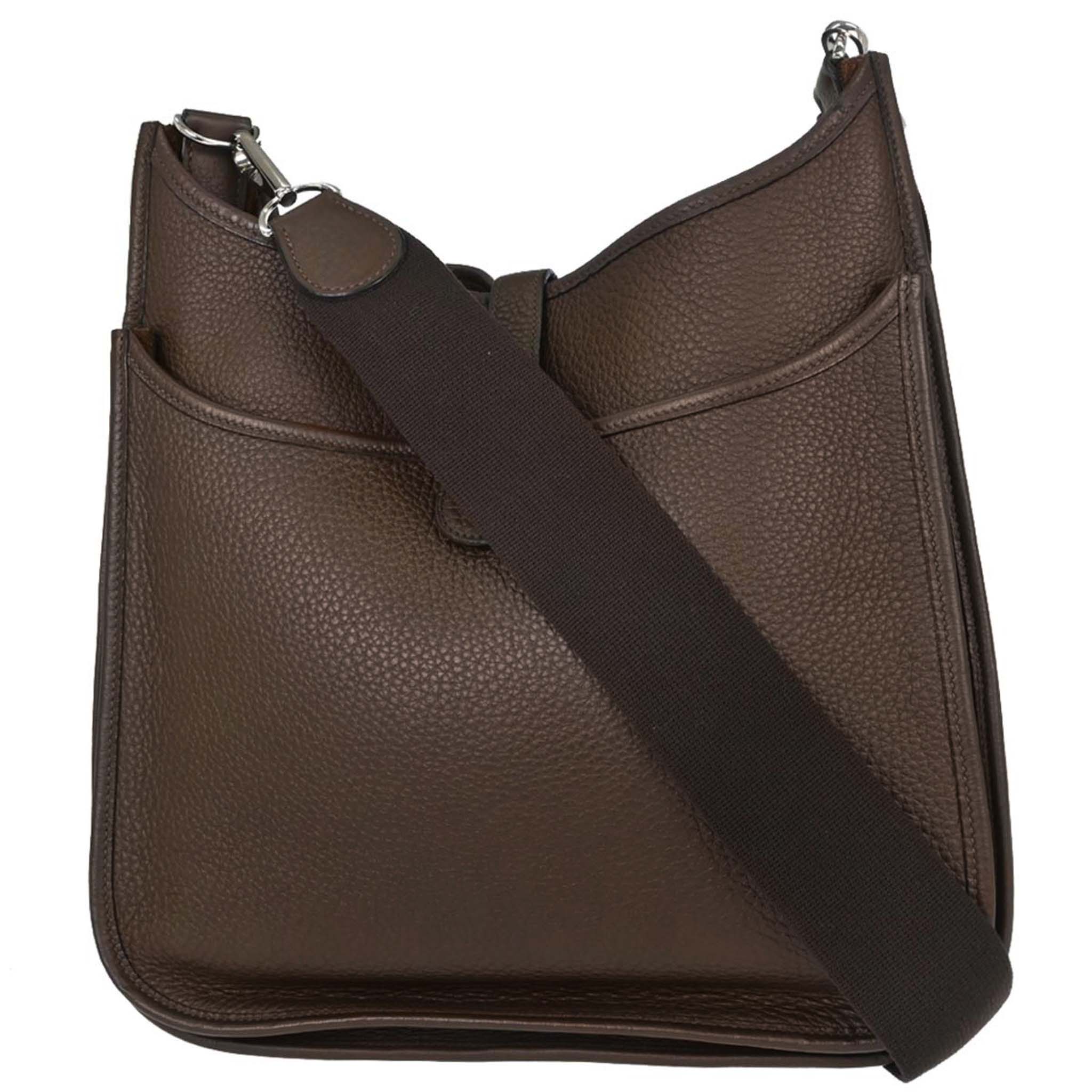 Brown grained leather shoulder bag with perforated design on the front and a wide strap