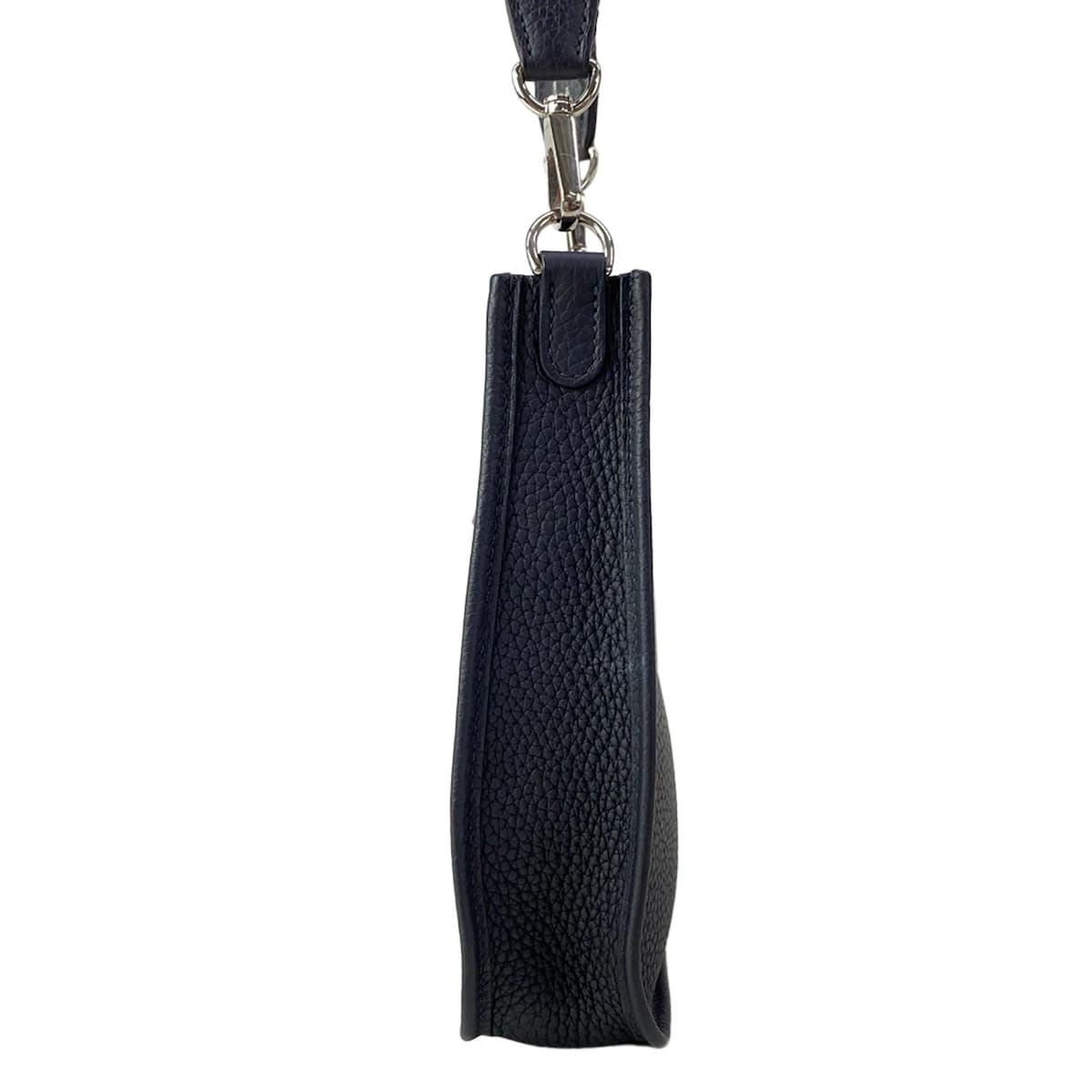 Small crossbody bag with a perforated logo on the front panel and a long flat strap.
