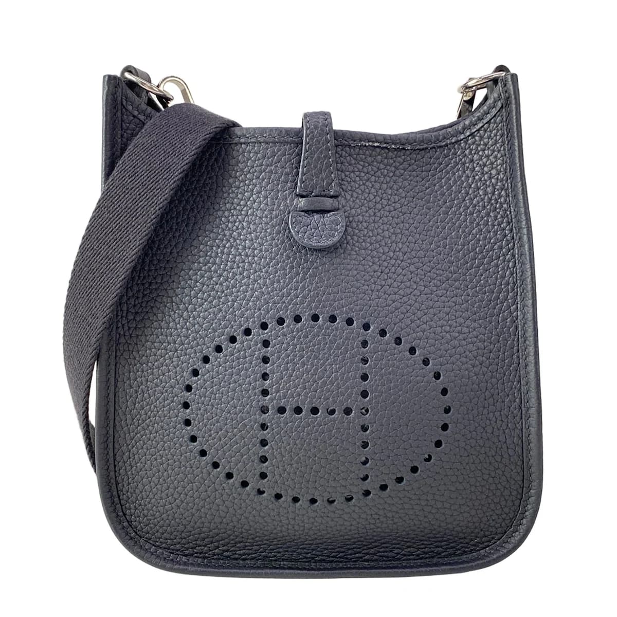 Small crossbody bag with a perforated logo on the front panel and a long flat strap.
