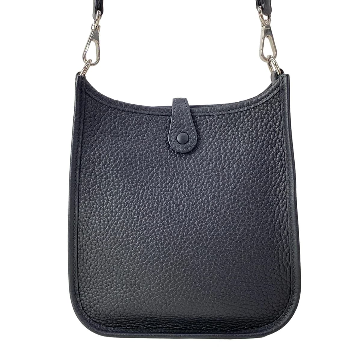 Small crossbody bag with a perforated logo on the front panel and a long flat strap.