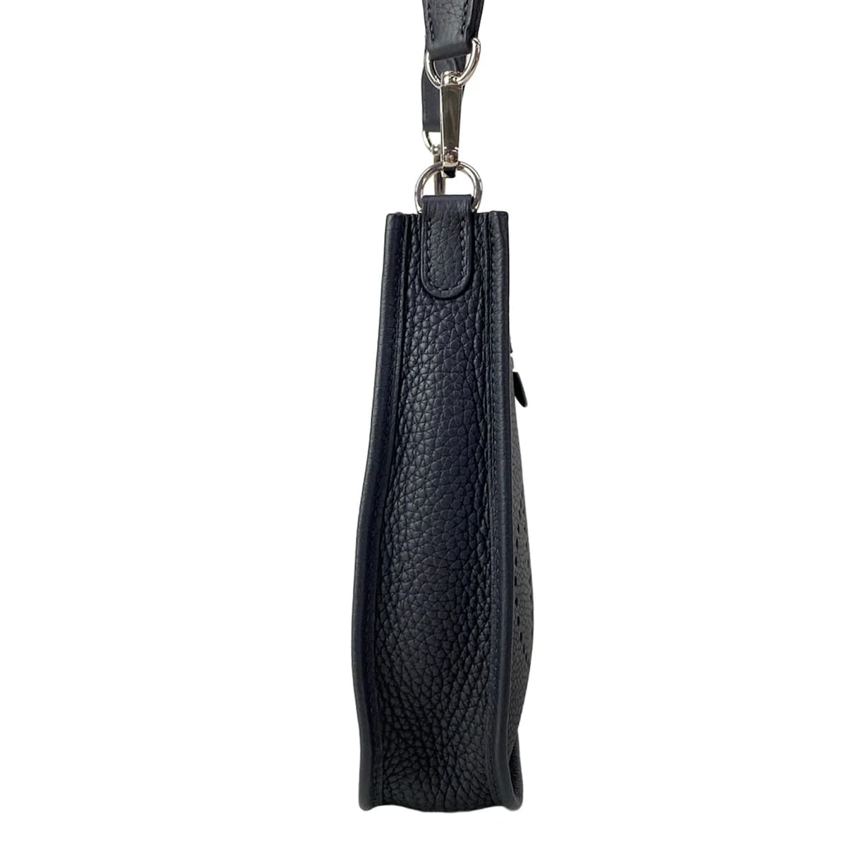 Small crossbody bag with a perforated logo on the front panel and a long flat strap.