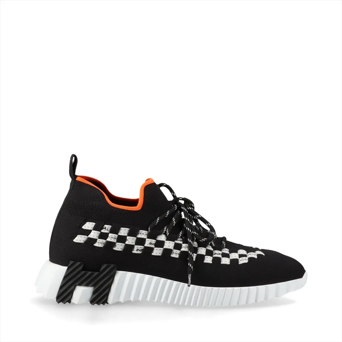 Black knit sneaker with white sole and white detailing at the heel.