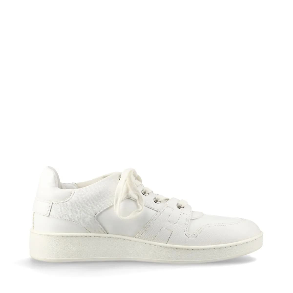 Pair of white leather low-top sneakers with visible yellowing on the upper