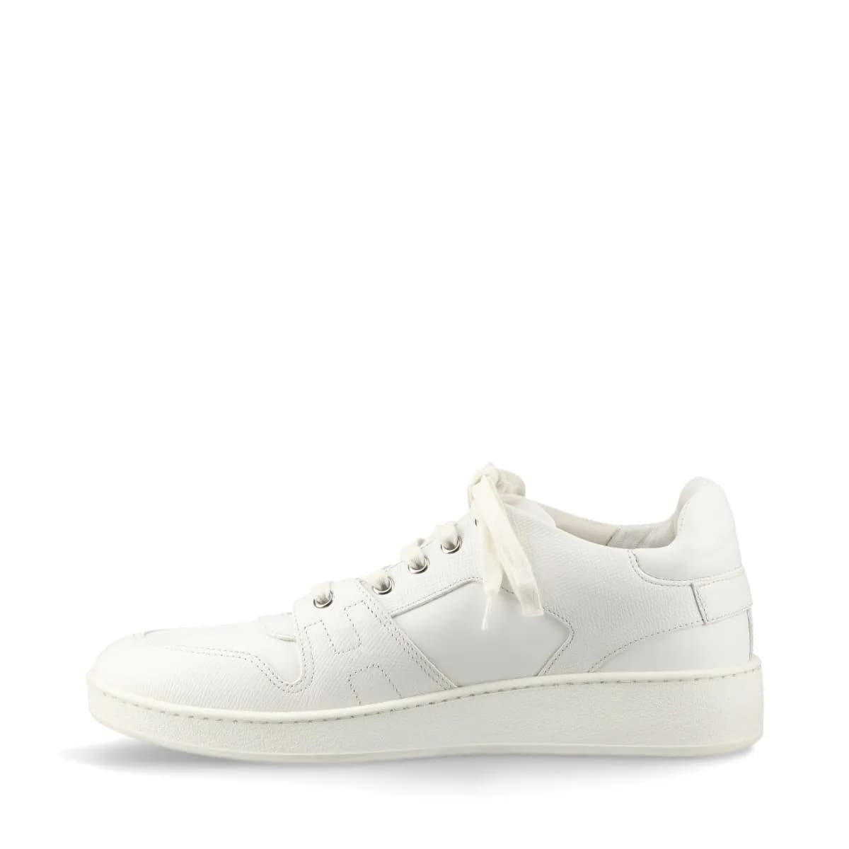 Pair of white leather low-top sneakers with visible yellowing on the upper