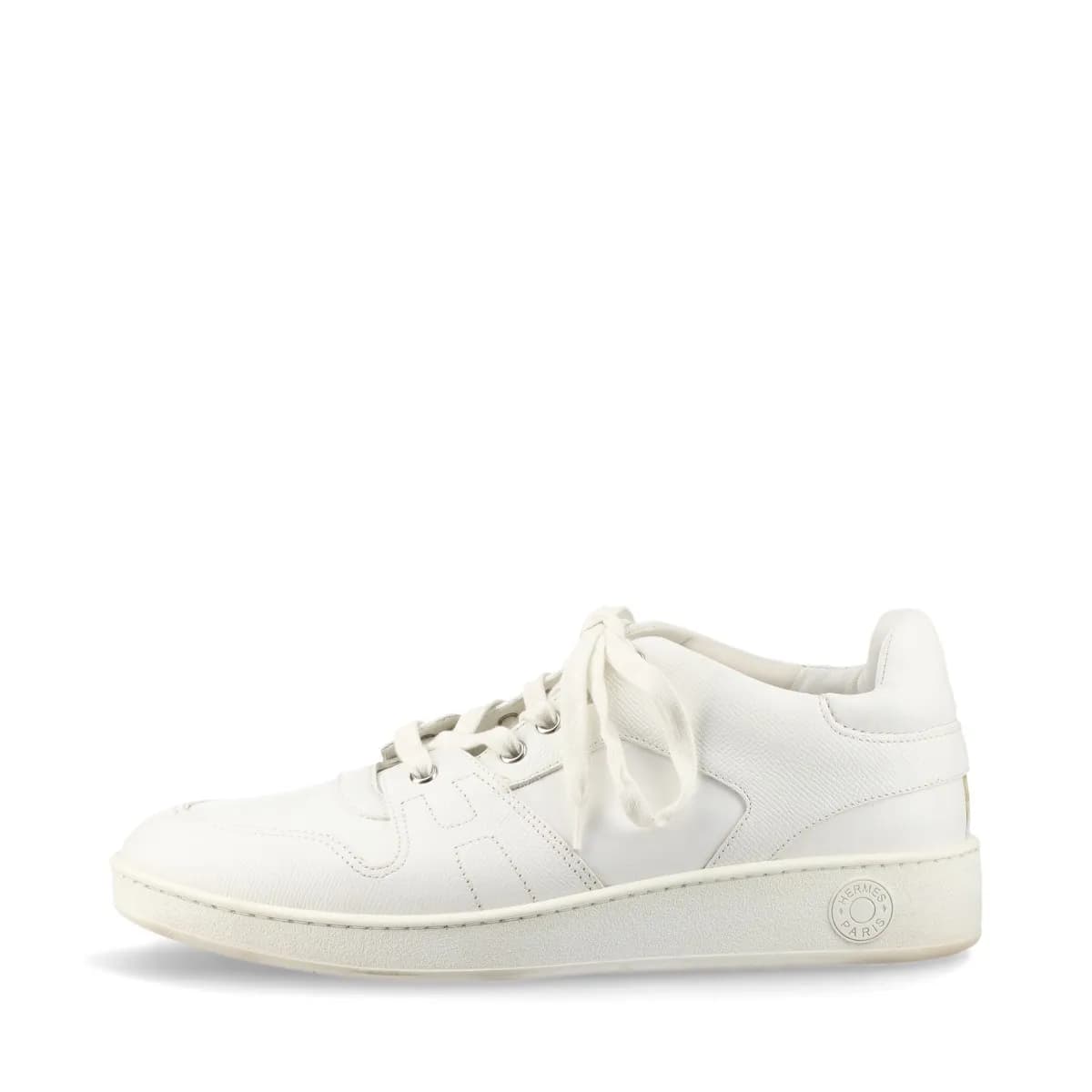 Pair of white leather low-top sneakers with visible yellowing on the upper