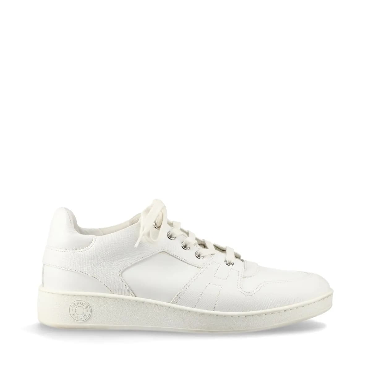 Pair of white leather low-top sneakers with visible yellowing on the upper