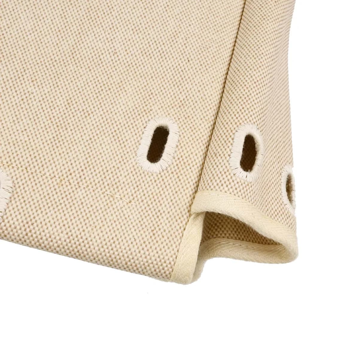 Canvas backpack with beige body, black leather trim and flap closure with straps.