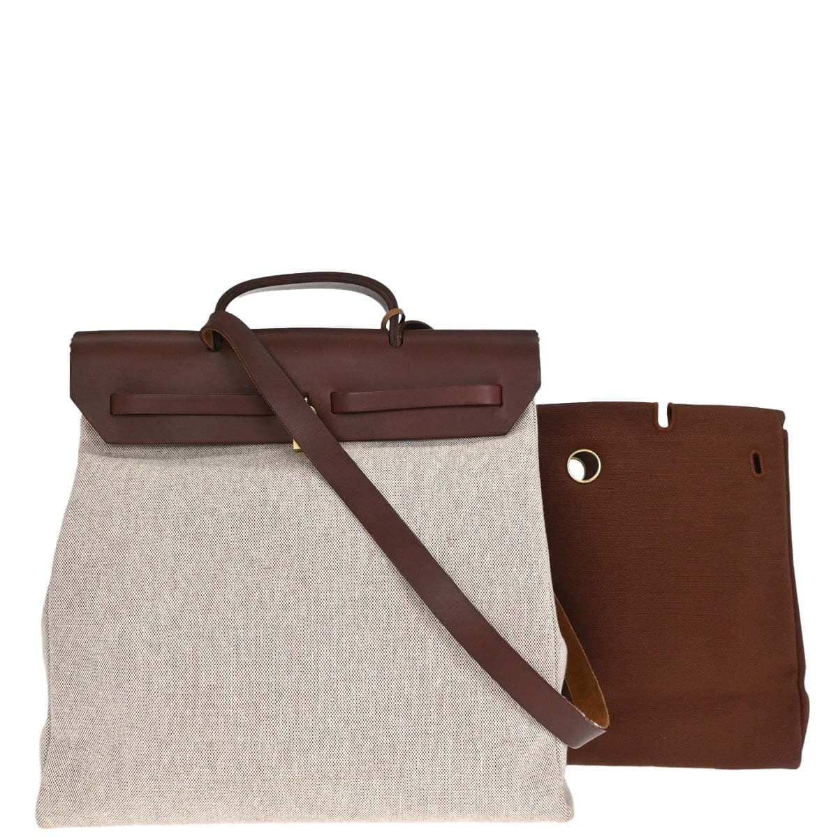 Trapeze-shaped canvas and leather bag with flap front, buckle closure and a long strap.