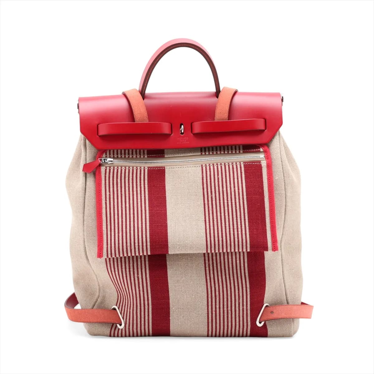 Red canvas bag with tan leather flap and base, silver clasp and a shoulder strap.