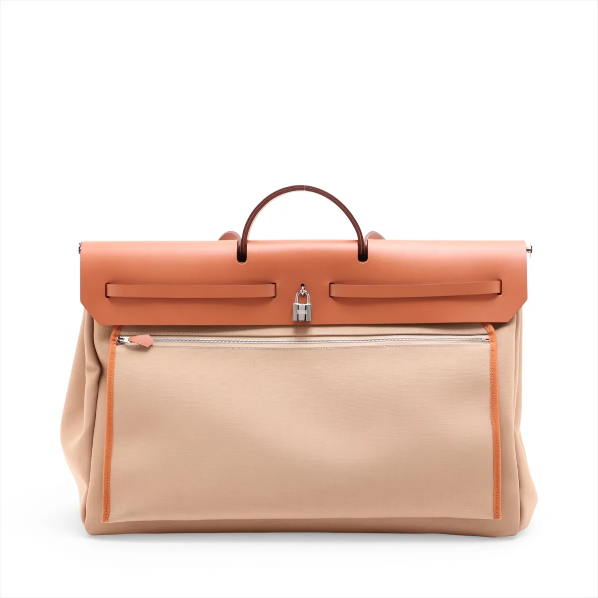 Beige canvas bag with tan leather flap and trim, front strap closure and a shoulder strap.