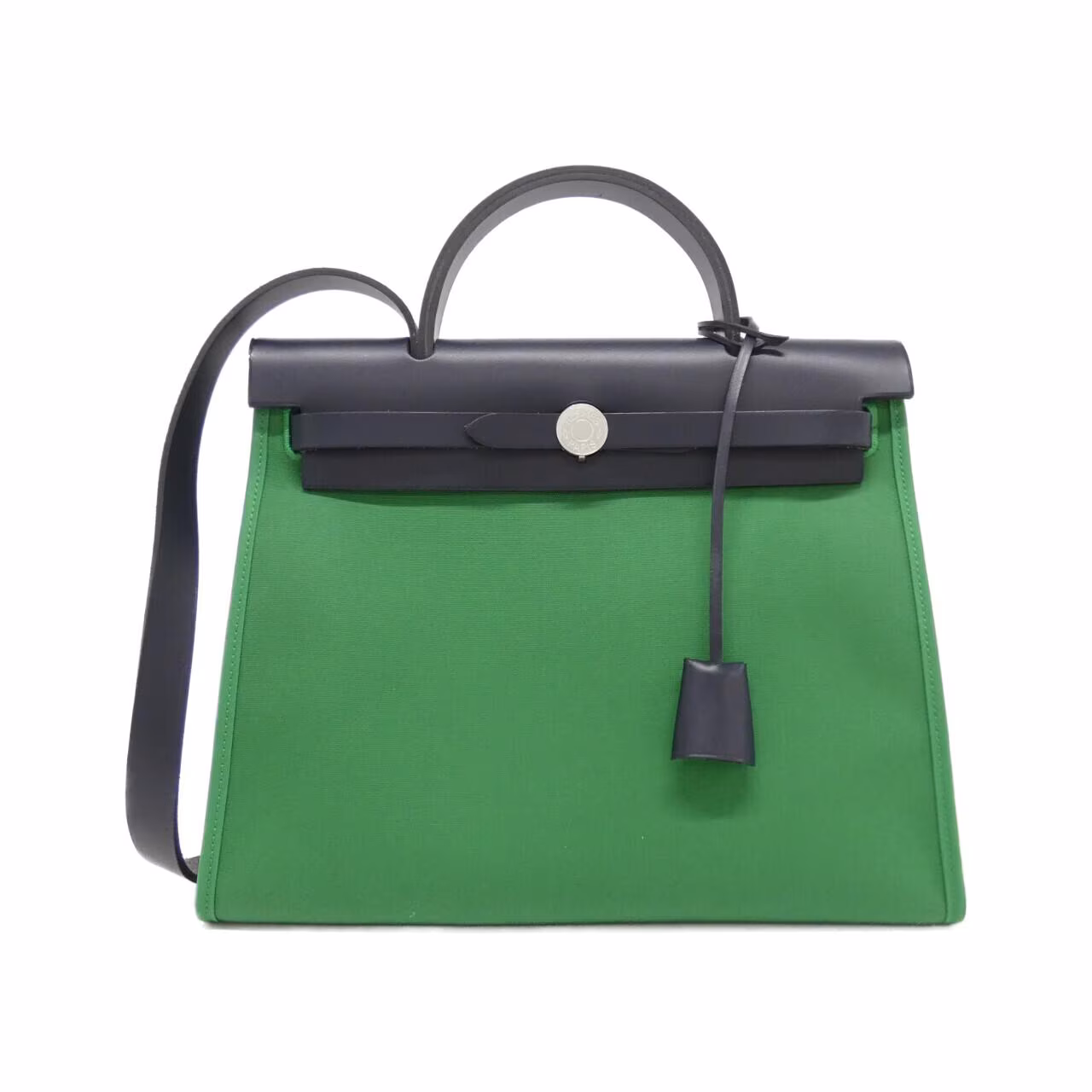 Structured flap bag with a canvas body and leather trim against a plain background.