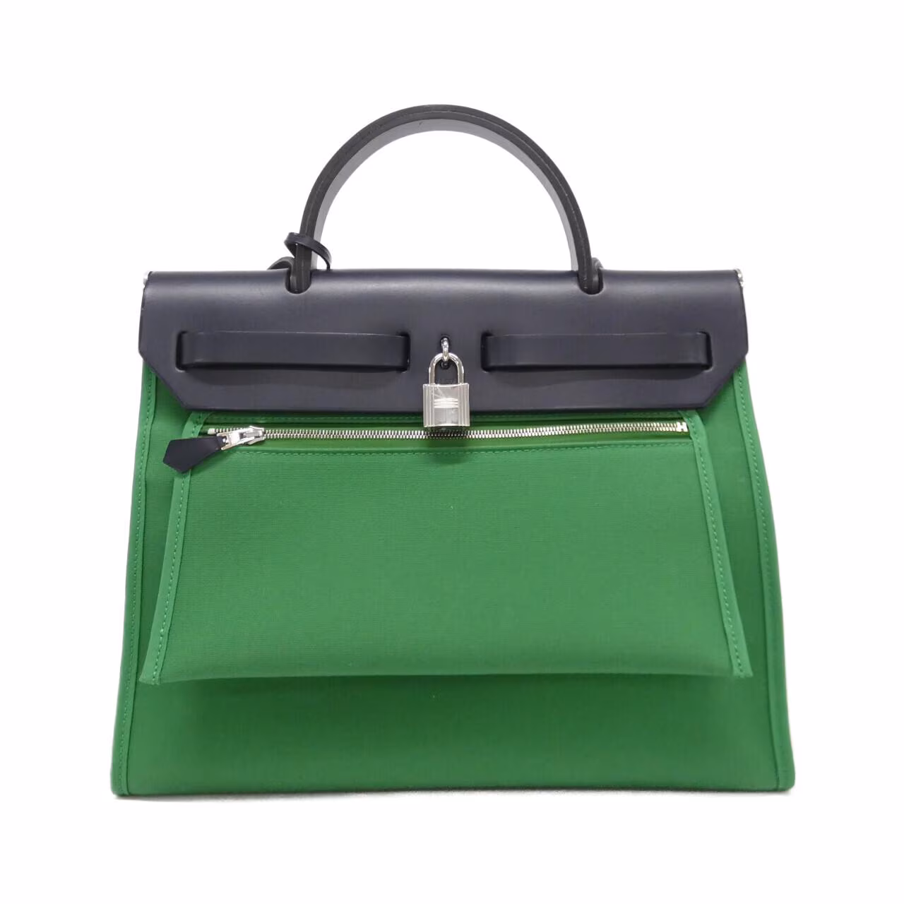 Structured flap bag with a canvas body and leather trim against a plain background.