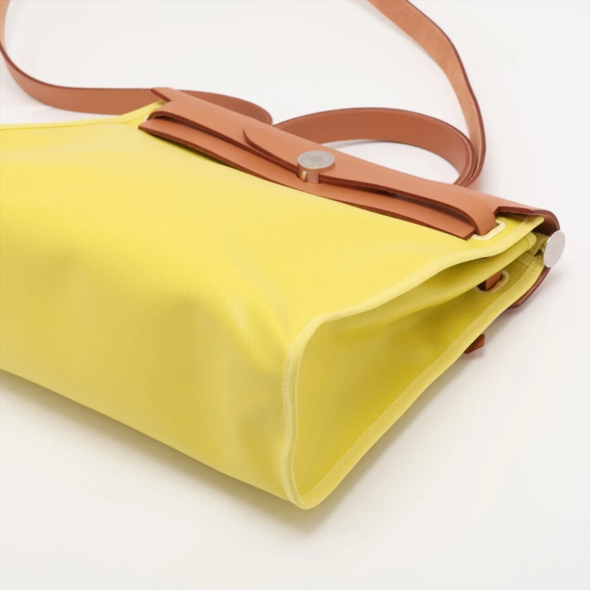 Lime green canvas bag with natural leather trim and silver-tone closure.